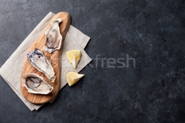Opened oysters and lemon Stock photo © karandaev