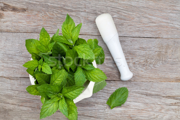 Fresh mint in mortar on garden table Stock photo © karandaev