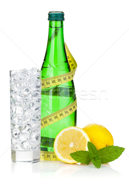 Glass of water with ice, bottle, measuring tape, lemon and mint Stock photo © karandaev