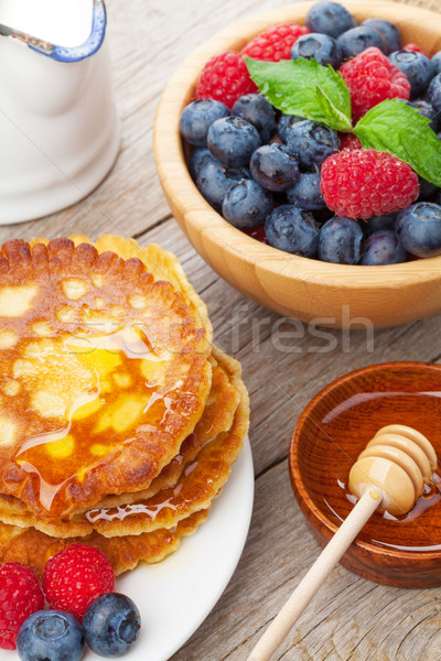 Pancakes with raspberry, blueberry, mint and honey syrup Stock photo © karandaev
