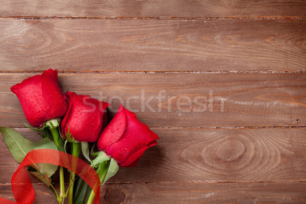 Red roses on wooden background Stock photo © karandaev