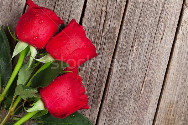 Red roses over wooden table Stock photo © karandaev