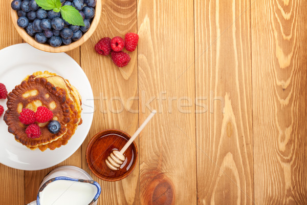Pancakes with raspberry, blueberry, mint and honey syrup Stock photo © karandaev