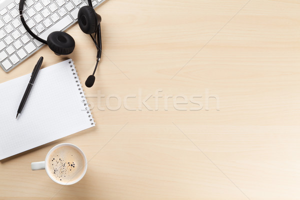 Stock photo: Office desk with headset, notepad and pc