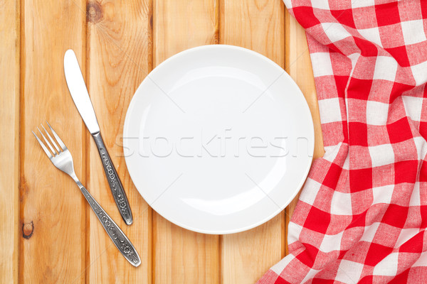 Empty plate, silverware and towel over wooden table background Stock photo © karandaev