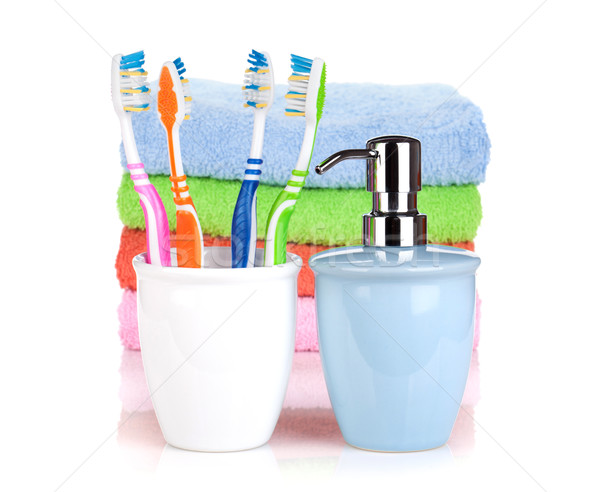 Four colorful toothbrushes, liquid soap and towels Stock photo © karandaev