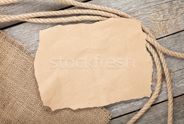 Old paper and rope on wooden textured background Stock photo © karandaev