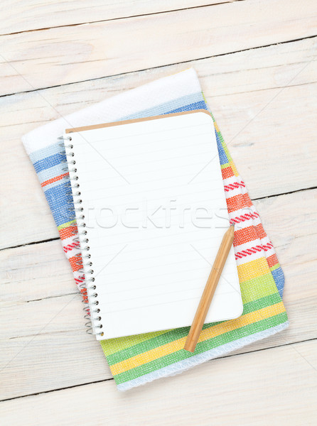 Notepad over kitchen towel on wooden table Stock photo © karandaev
