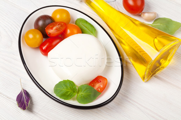 Mozzarella tomates basilic huile d'olive table en bois feuille Photo stock © karandaev