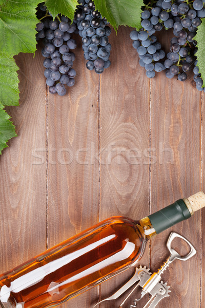Wine bottle and grapes on garden table Stock photo © karandaev