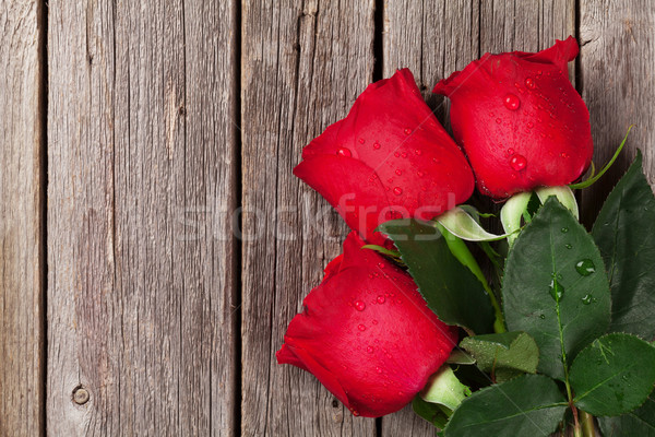 Red roses over wooden table Stock photo © karandaev