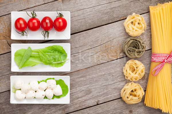 Tomatoes, mozzarella, pasta and green salad leaves Stock photo © karandaev