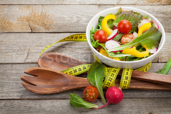 Fresh healthy salad, utensil and measure tape Stock photo © karandaev