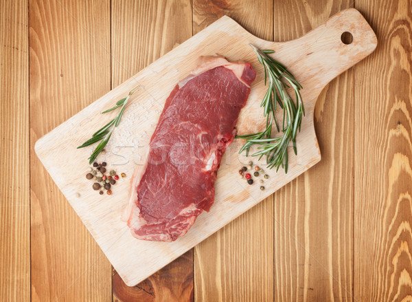 Raw sirloin steak with rosemary and spices on cutting board Stock photo © karandaev