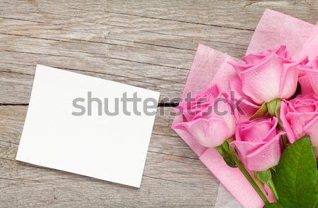 Pink roses bouquet and blank greeting card over wooden table Stock photo © karandaev