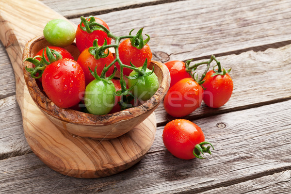 Tomates cereja tigela mesa de madeira comida folha fundo Foto stock © karandaev