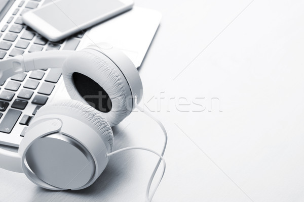 Headphones over laptop on wooden desk table Stock photo © karandaev