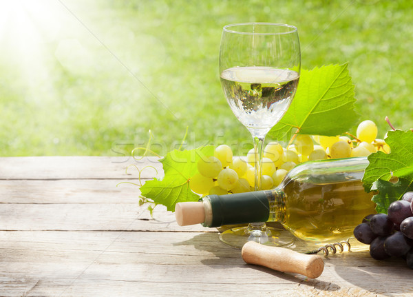 Stock photo: White wine glass and bottle with bunch of grapes