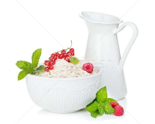 Fresh oat flakes with berries and milk jug Stock photo © karandaev