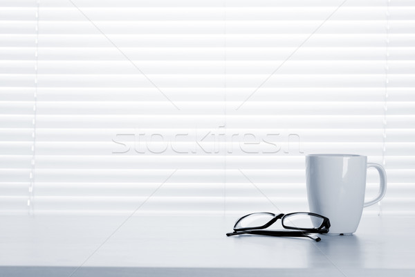 Office desk workplace with coffee cup and glasses Stock photo © karandaev