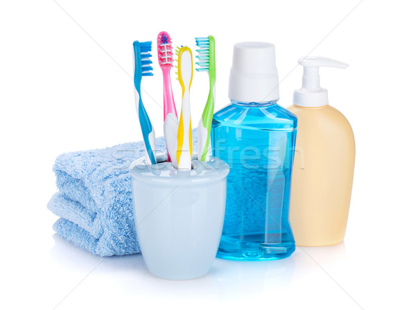 Four colorful toothbrushes, cosmetics bottles and towel Stock photo © karandaev