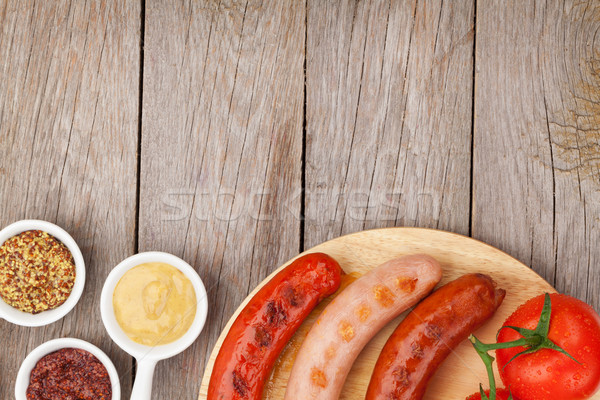 Various grilled sausages with condiments and tomatoes Stock photo © karandaev