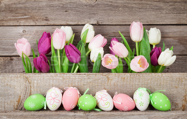 Easter eggs and colorful tulips Stock photo © karandaev