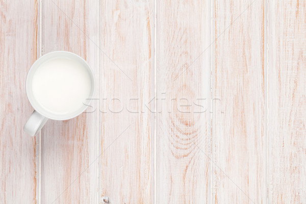 Cup of milk on white wooden table Stock photo © karandaev