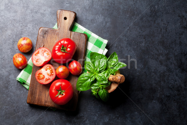 Fresh ripe garden tomatoes and basil on stone table Stock photo © karandaev