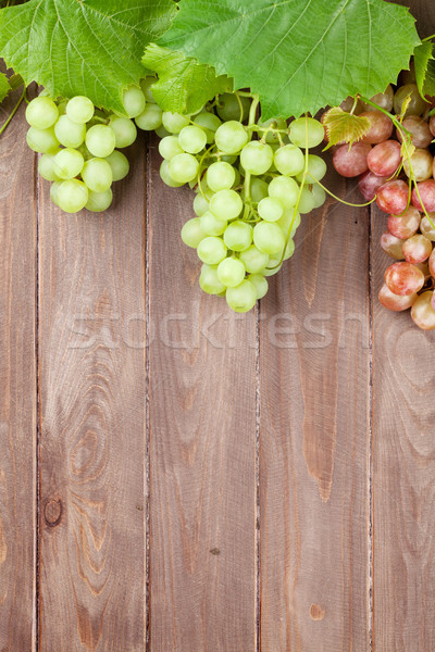 Bunch of grapes and vine on wooden table Stock photo © karandaev