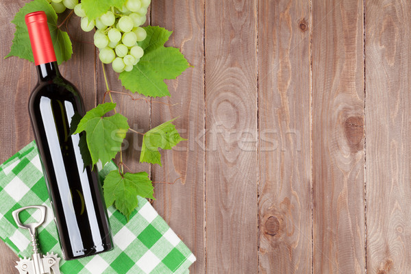 Köteg szőlő vörösbor üveg dugóhúzó fa asztal Stock fotó © karandaev