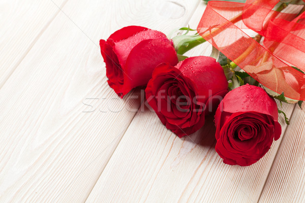 Red roses over wooden table Stock photo © karandaev