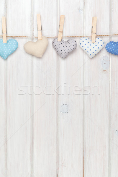 Valentines day toy hearts hanging on rope over white wooden back Stock photo © karandaev