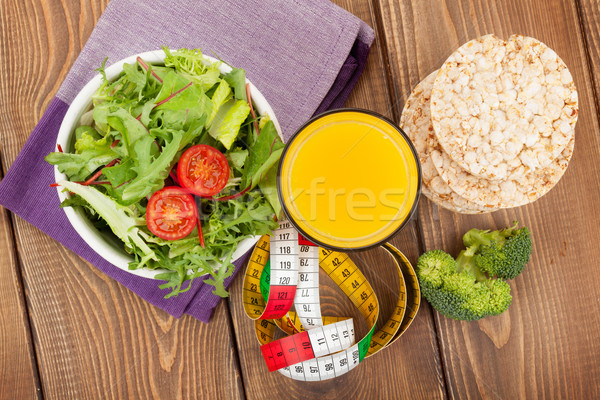 Healthy food and tape measure over wooden table Stock photo © karandaev