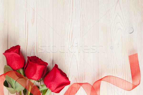 Red roses on wooden background Stock photo © karandaev