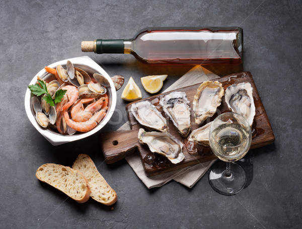 Fresh seafood and white wine on stone table Stock photo © karandaev