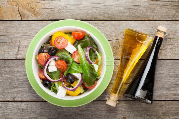 Fresh healthy greek salad and condiment bottles Stock photo © karandaev