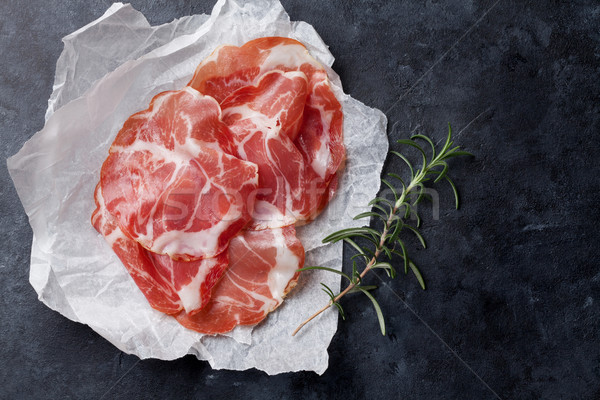 Slices of prosciutto on paper Stock photo © karandaev