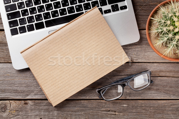 Desk table with laptop, notepad and glasses Stock photo © karandaev