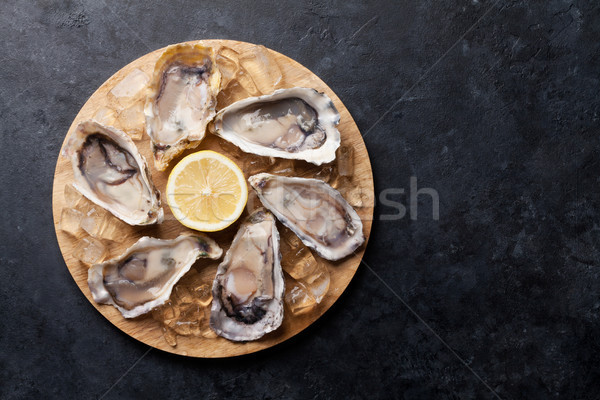 Oysters and lemon over ice Stock photo © karandaev