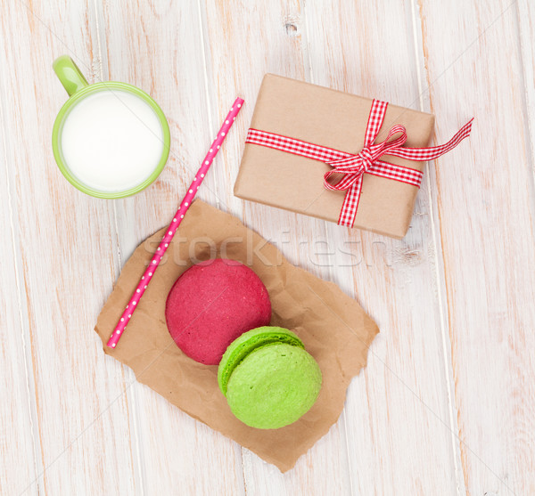 Colorful macarons, cup of milk and gift box Stock photo © karandaev
