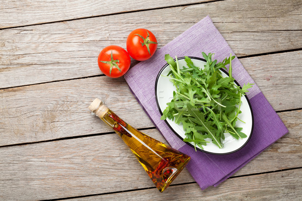 Arugula salad, tomatoes and olive oil bottle Stock photo © karandaev