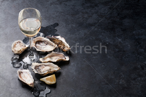 Oysters with lemon and white wine Stock photo © karandaev