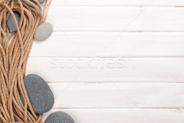 Wooden background with marine rope and sea stones Stock photo © karandaev