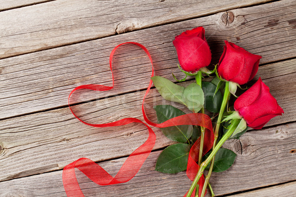 Red roses and heart shape ribbon over wood Stock photo © karandaev