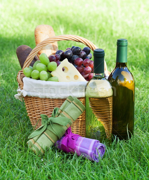 Outdoor picnic basket with wine on lawn Stock photo © karandaev