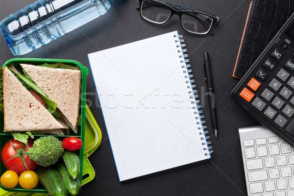 Office desk with supplies and lunch box Stock photo © karandaev