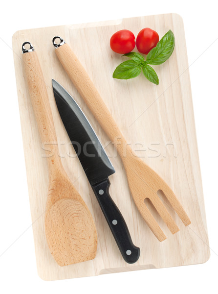 Cooking utensils and tomato with basil over cutting board Stock photo © karandaev