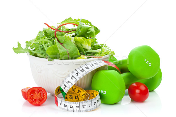 Two green dumbells, tape measure and healthy food. Fitness and h Stock photo © karandaev