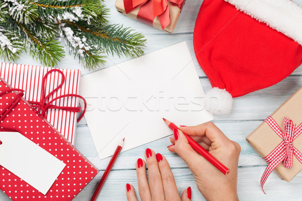 Stock photo: Female writing christmas greeting card and gift wrapping